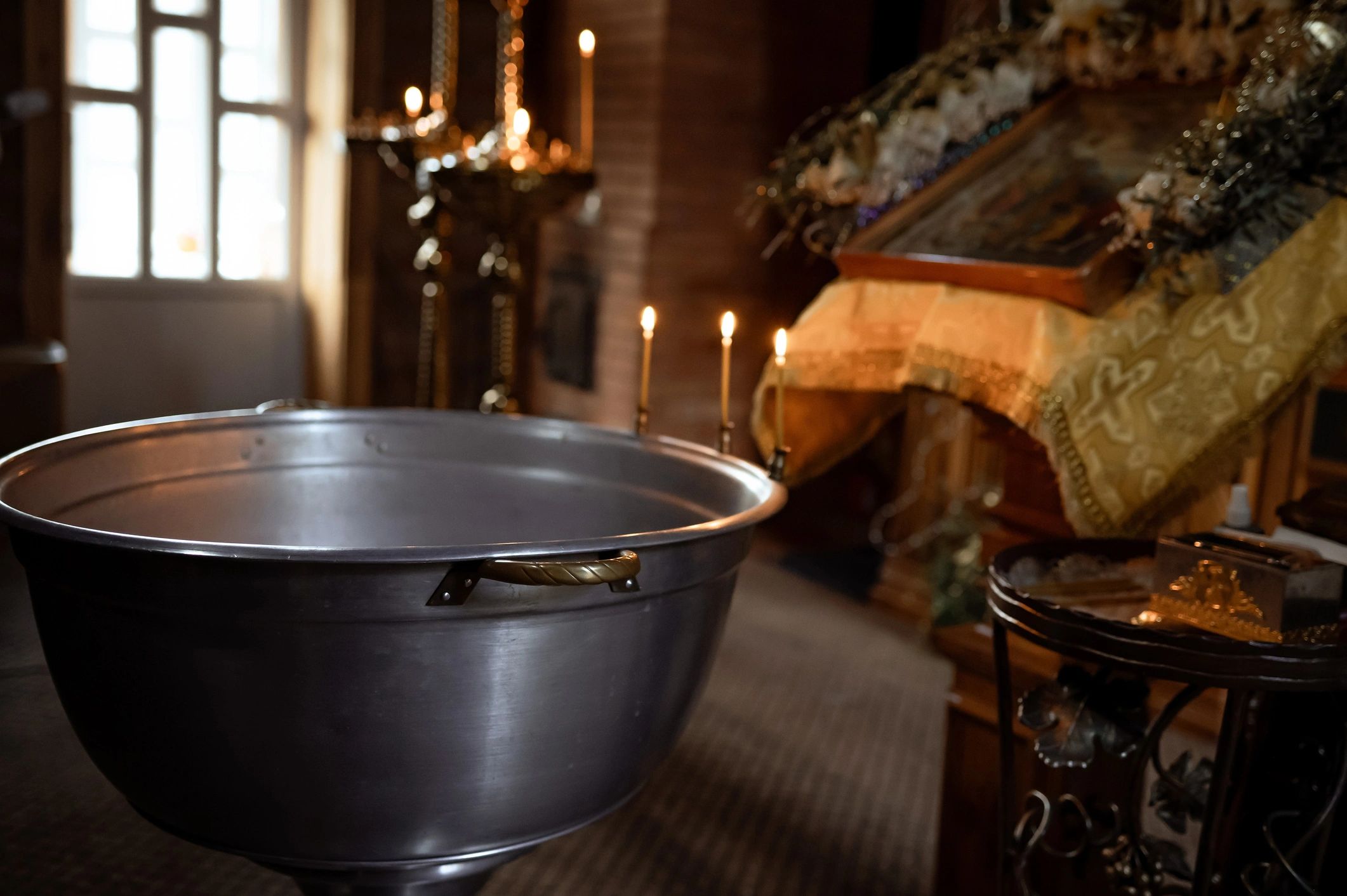 Baptismal font and candles inside a Christian church